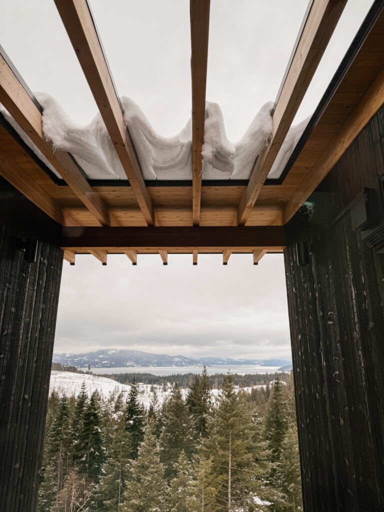 Exposed timber roof structure designed to manage heavy snow loads in a high-end custom home overlooking North Idaho forest and lake views